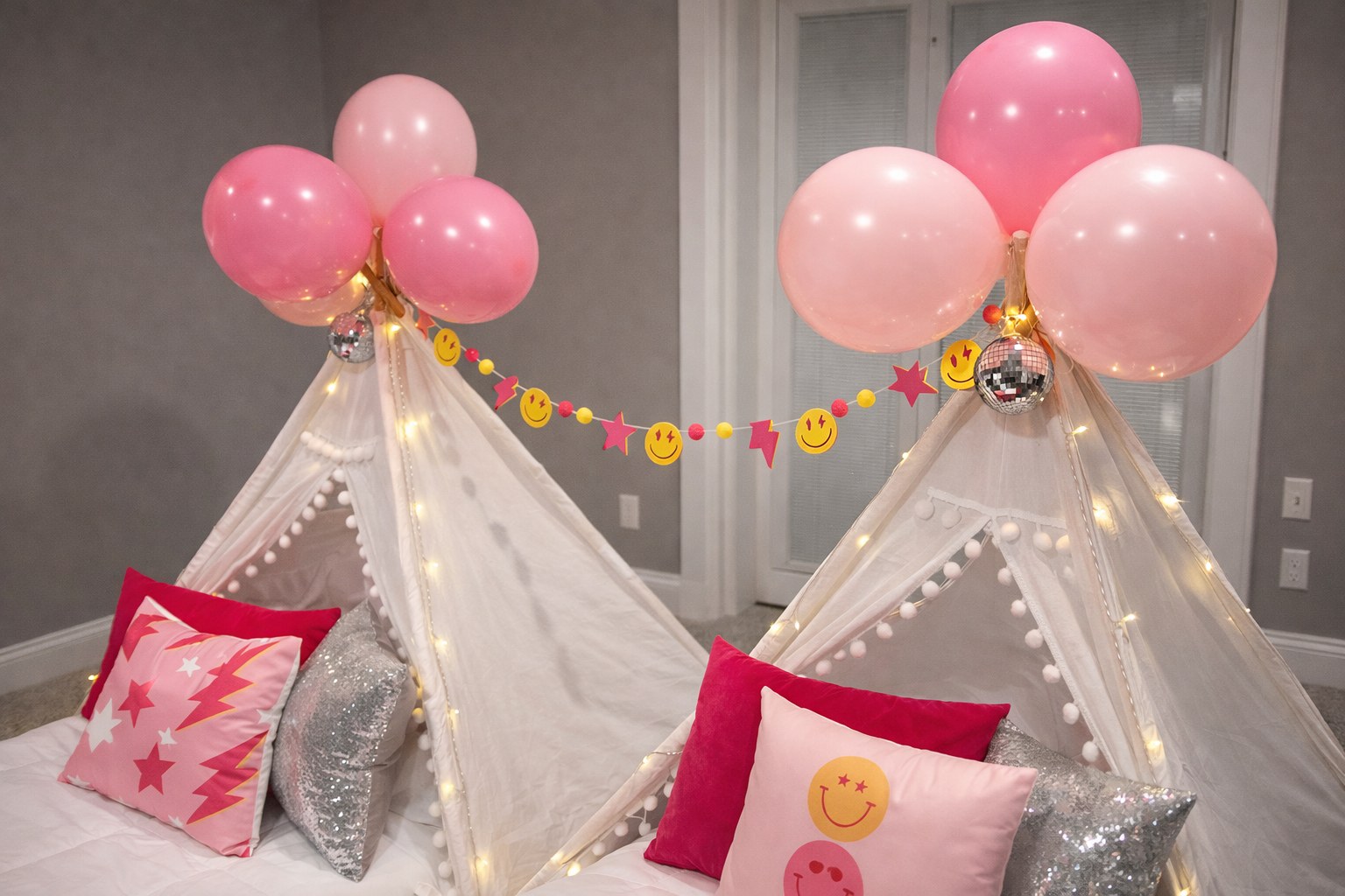 Two teepee sleepover parties with pink balloon clusters and smiley face banner — Sleepover Club Timonium MD