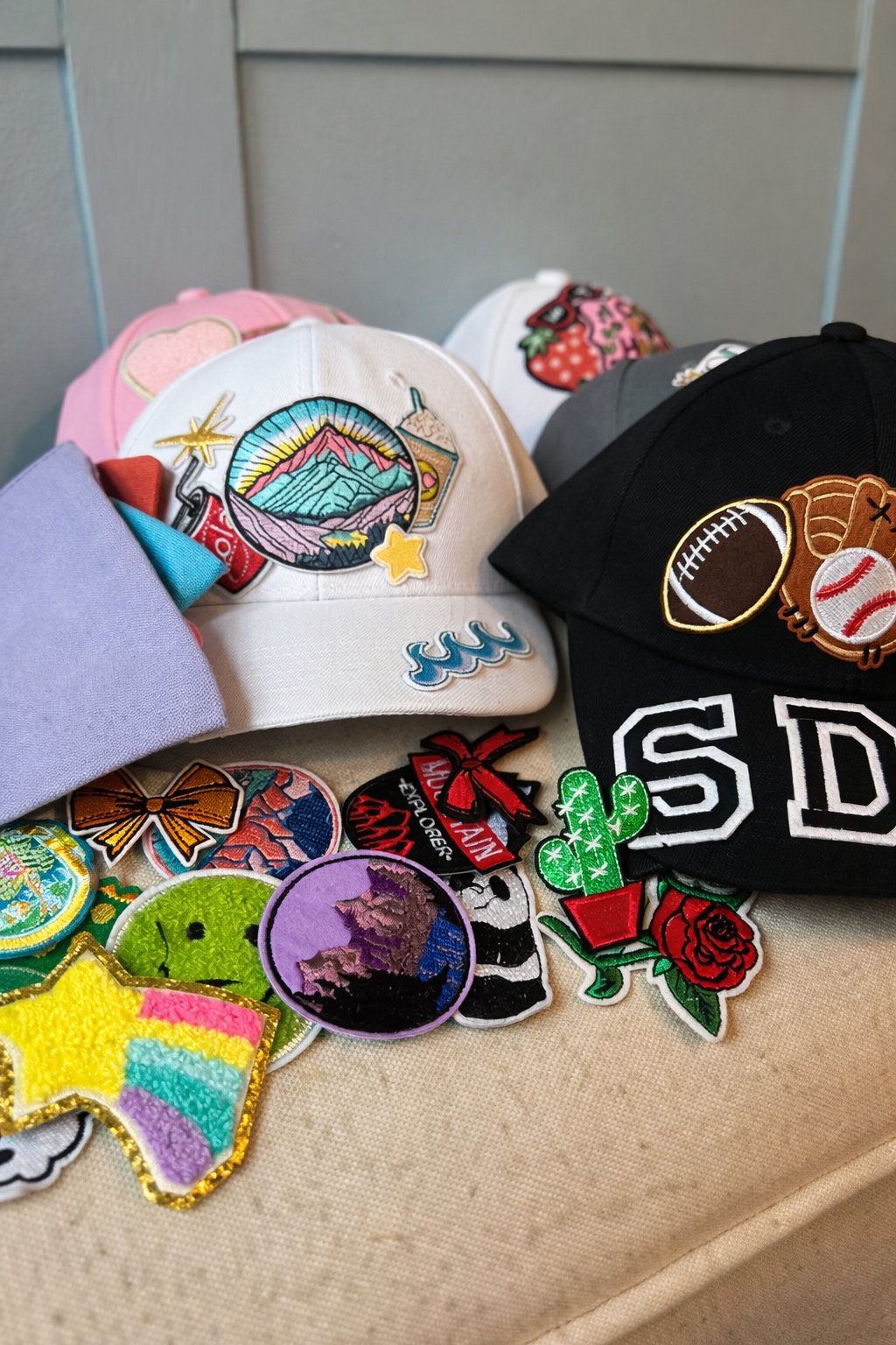 Custom hats with colorful iron-on patches displayed at a sleepover party box activity — Sleepover Club Timonium MD