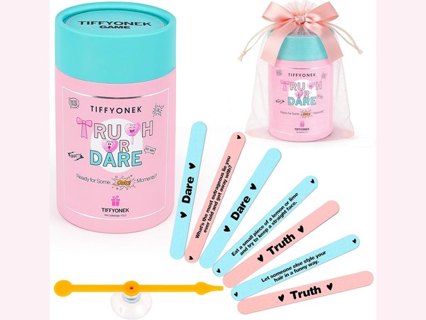 Pastel truth or dare card deck fanned out on a pink background with sparkles