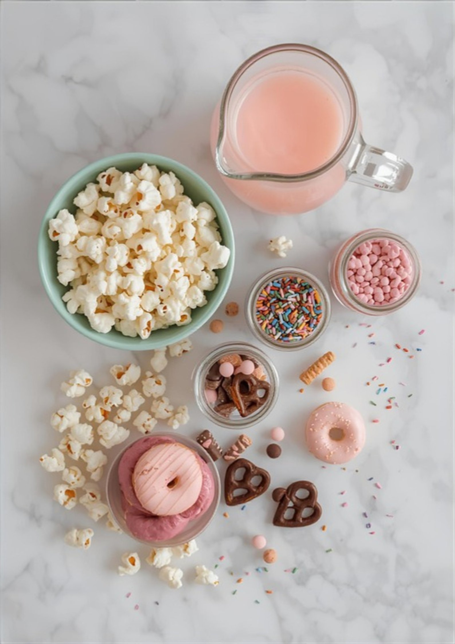 A sleepover snack bar spread with popcorn boxes, candy jars, kraft bags, and hand-lettered labels
